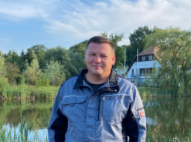 Mitarbeiter Grüner Bereich vor einem Teich